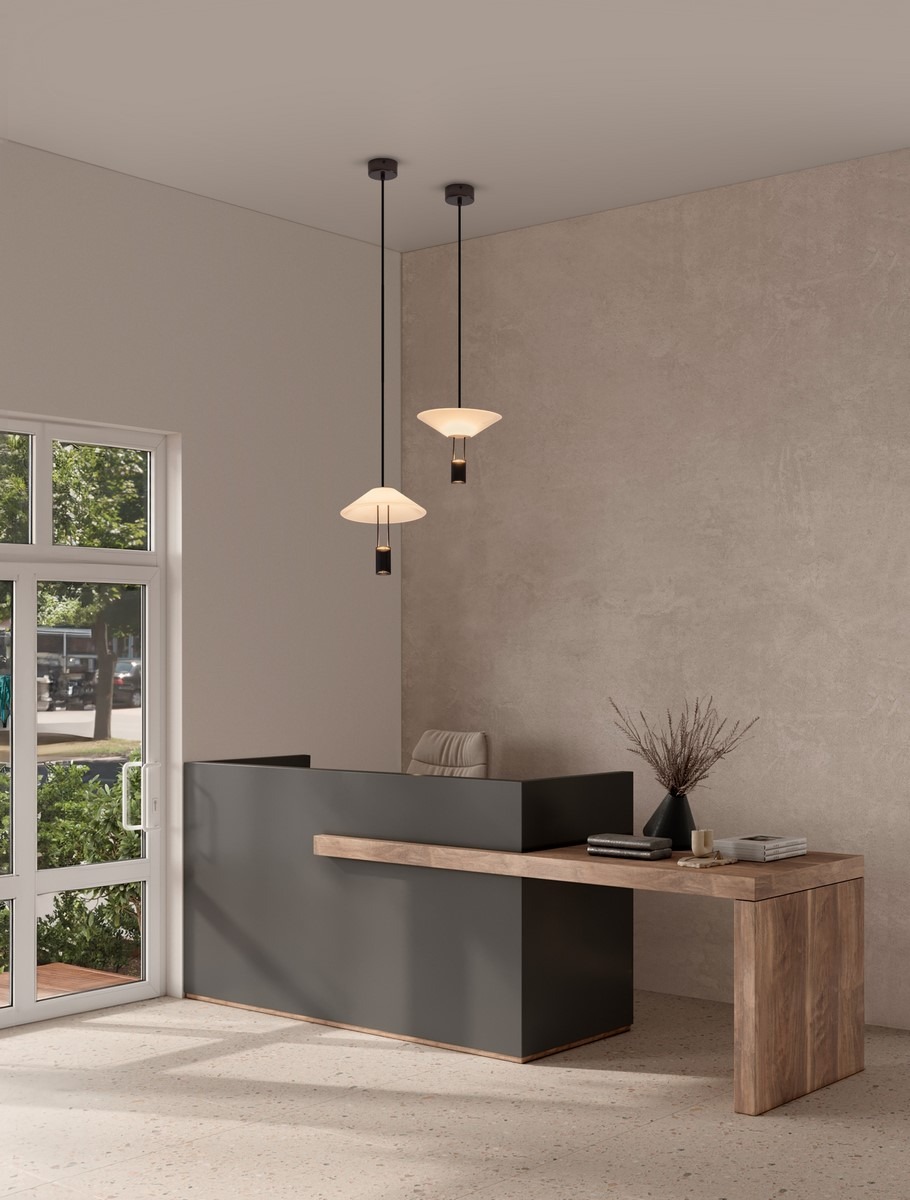 Lampa wisząca Ayaviri 1xLED 8W w kolorze czarnym, z kloszem o kształcie stożka, zawieszona na cienkim przewodzie. Ujęcie frontalne, w aranżacji biurowej, nad nowoczesnym biurkiem. Tło w odcieniach beżu i szarości.