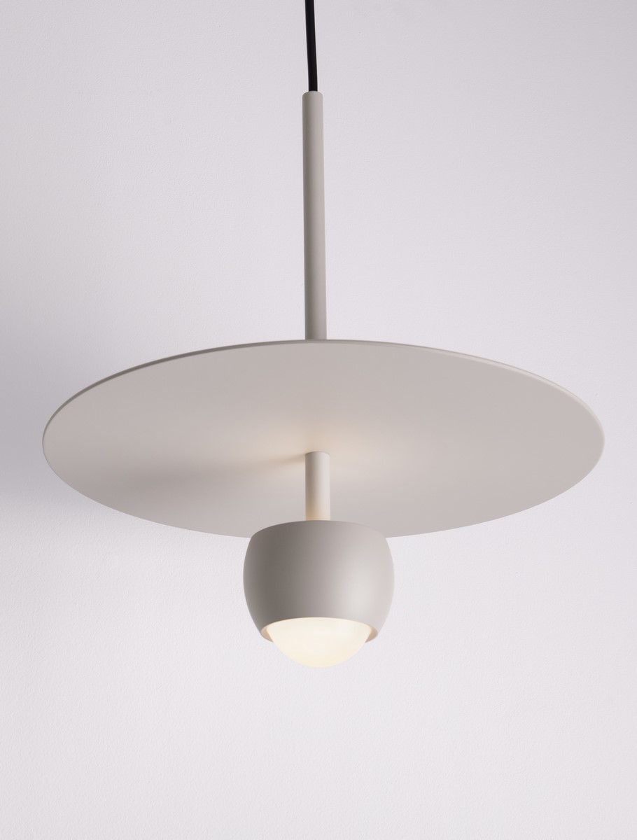Lampa wisząca Baila w kolorze beżowym z jedną żarówką LED 8W. Okrągła, płaska podsufitka oraz kulisty klosz z matowego materiału. Ujęcie z dołu, zawieszona na cienkim przewodzie, w minimalistycznym stylu, na jasnym tle.