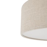 Lampa wisząca Santana M w kremowym kolorze, z abażurem o teksturowanej powierzchni. Ujęcie z bliska, pokazujące górną część lampy. Abażur jest cylindryczny, z białym wnętrzem, przeznaczona na żarówkę E27.
