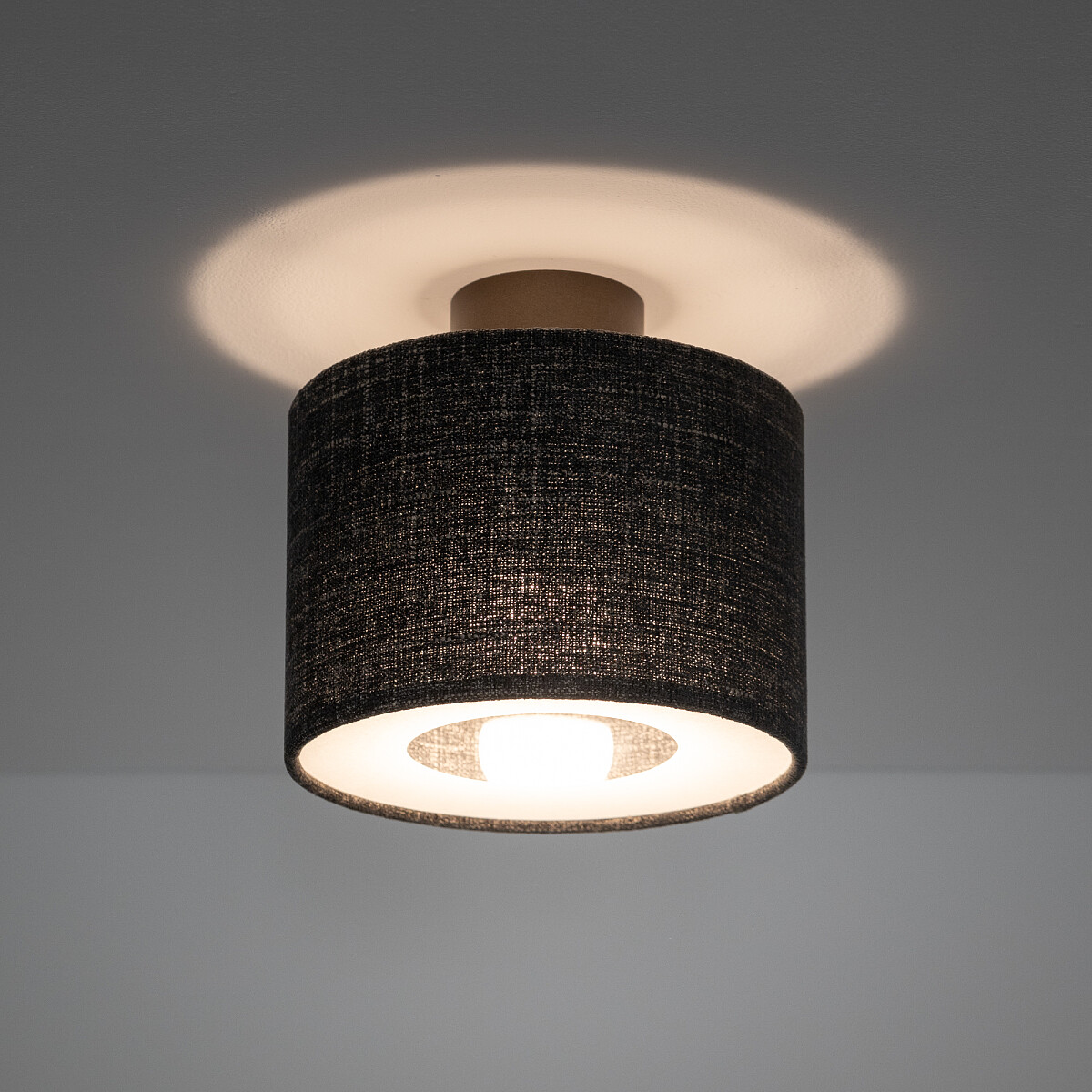Lampa sufitowa Amarela S z czarnym melanżowym abażurem, okrągła, z widocznym źródłem światła E27. Montaż górny, w tle jasny sufit, tworzy subtelne oświetlenie.