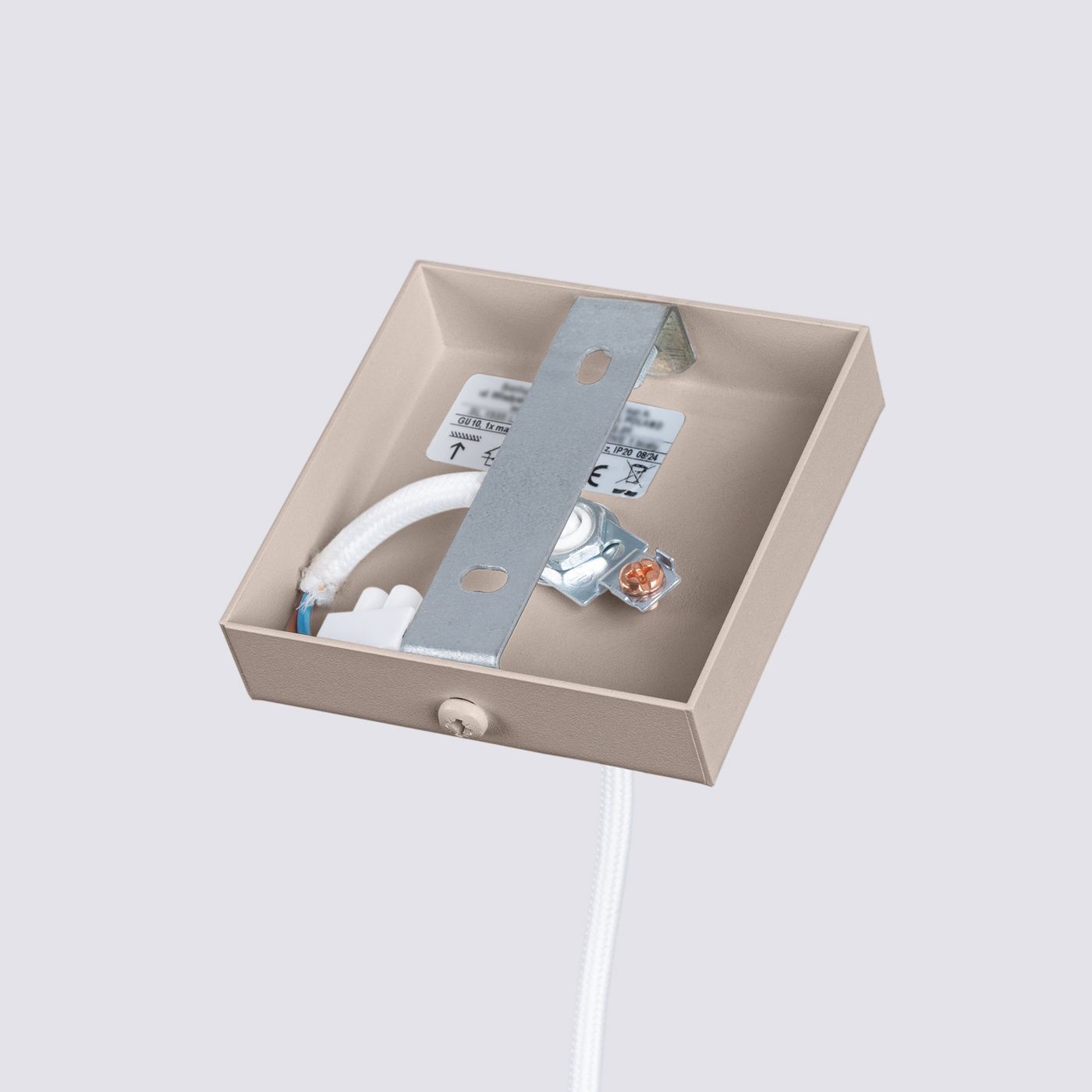 Lampa wisząca Karbon 1, kolor taupe, z jednym gniazdem GU10. Widok od góry na metalowy uchwyt montażowy i przewody elektryczne w obudowie. Prosta, kwadratowa konstrukcja, z wyraźnie widocznymi oznaczeniami elektrycznymi.