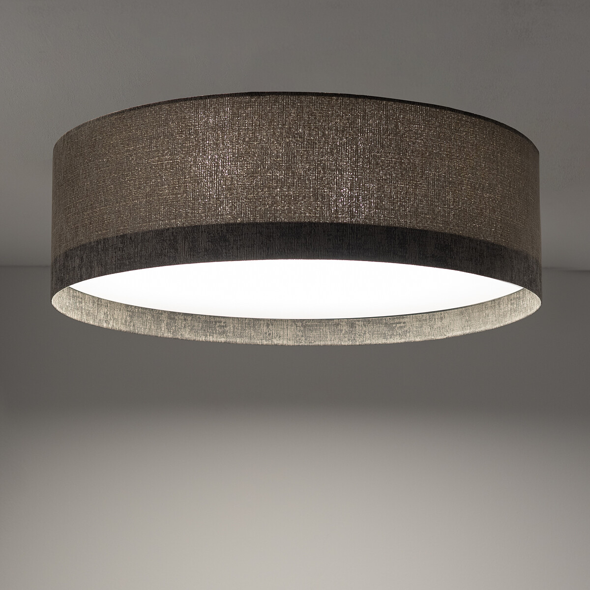 Lampa sufitowa Lago M z czterema gniazdami E27, w okrągłej, szarej obudowie z teksturowanego materiału. Ujęcie z dołu, ukazujące szeroki klosz oraz białą, rozproszoną powierzchnię świetlną, montowana na suficie.