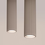 Lampa wisząca Karbon 2, kolor taupe, z dwiema cylindrycznymi, żebrowanymi oprawami. Ujęcie z bliska, pokazujące detale struktury oraz źródła światła GU10. Produkt wisi w neutralnym tle, podkreślając jego nowoczesny design.