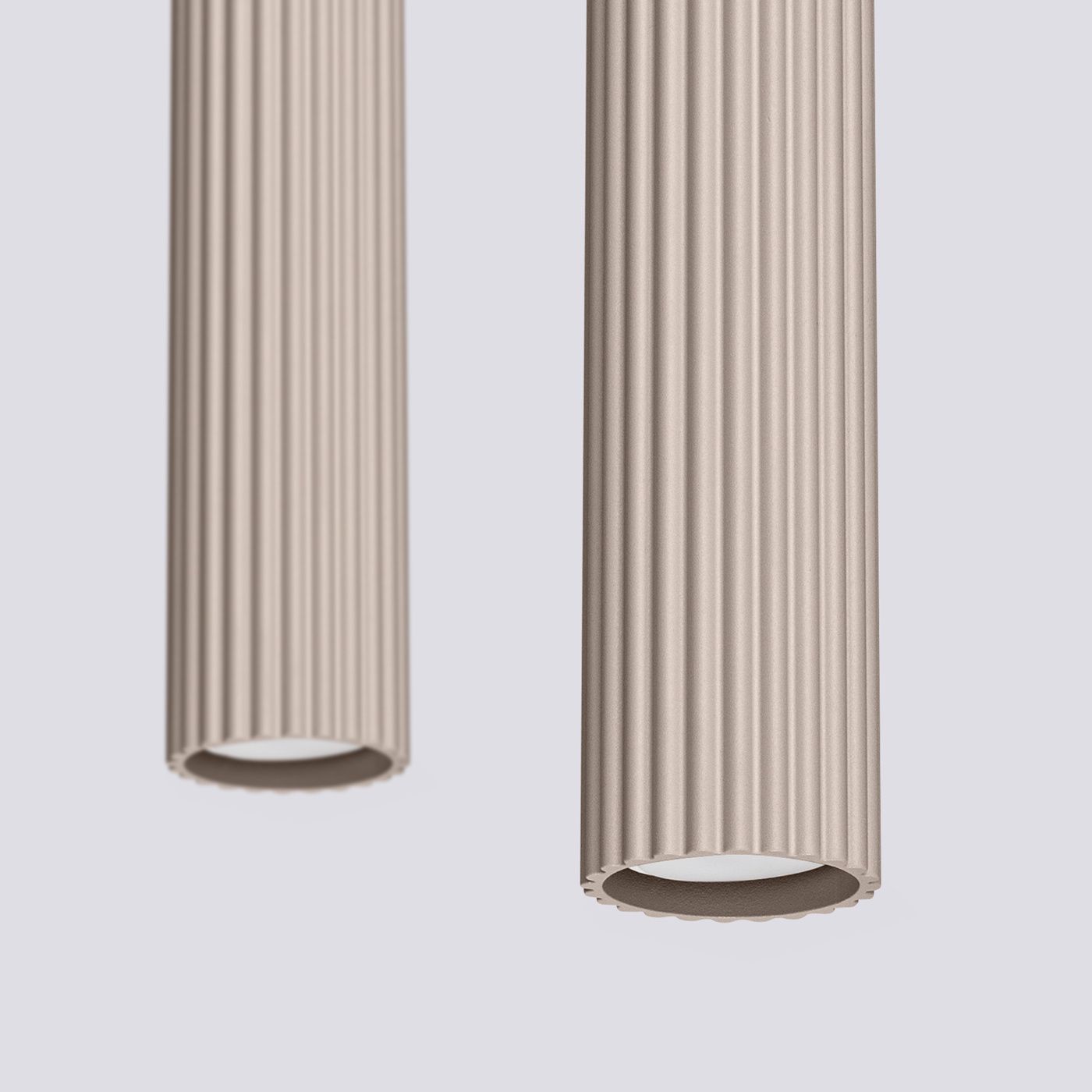 Lampa wisząca Karbon 2, kolor taupe, z dwiema cylindrycznymi oprawami z wypukłą teksturą. Ujęcie z bliska, przedstawiające szczegóły kształtu i faktury. Wbudowane gniazda na żarówki GU10, zawieszone w pozycji pionowej.