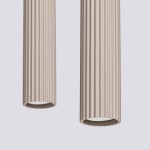 Lampa wisząca Karbon 2, kolor taupe, z dwiema cylindrycznymi oprawami z wypukłą teksturą. Ujęcie z bliska, przedstawiające szczegóły kształtu i faktury. Wbudowane gniazda na żarówki GU10, zawieszone w pozycji pionowej.