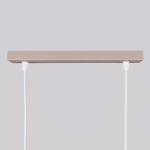 Lampa wisząca Karbon 2, kolor taupe, z dwoma gniazdami GU10. Posiada prostokątną, matową podstawę oraz białe kable zawieszenia. Ujęcie frontalne, ukazujące górną część lampy. Tło jednolite, szare.