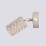 Kinkiet Karbon w kolorze taupe, z włącznikiem, z cylindrycznym kloszem o żłobionej fakturze. Ujęcie z boku, pokazujące ruchomy element lampy zamontowany na okrągłej podstawie. Tło jednolite, jasne.