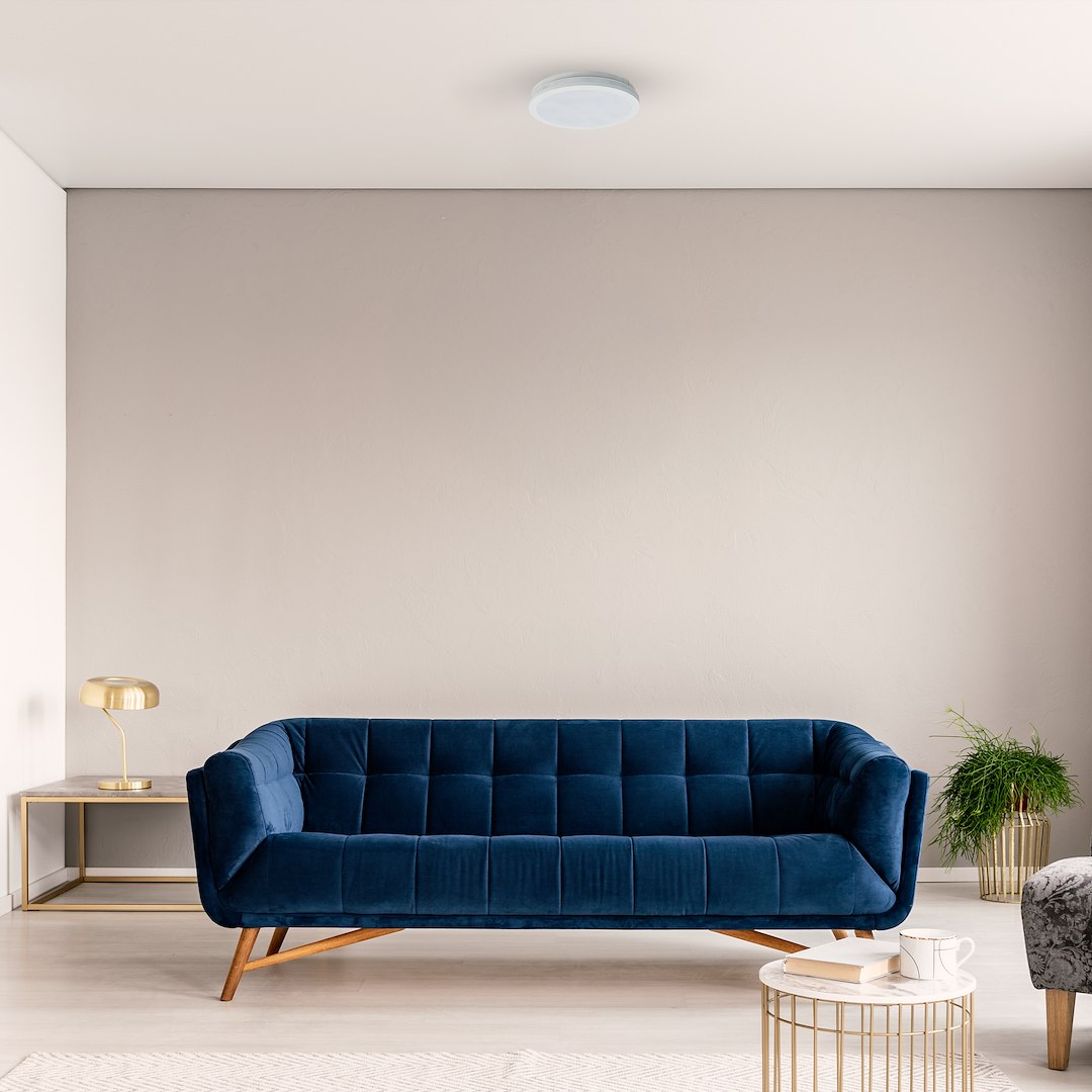 Plafon LED Marlon D30 w kolorze białym, o mocy 36W i temperaturze barwowej 4000K, zamontowany na suficie. Okrągły kształt z matowym wykończeniem, umieszczony w nowoczesnym wnętrzu z niebieską sofą i złotą lampą obok.