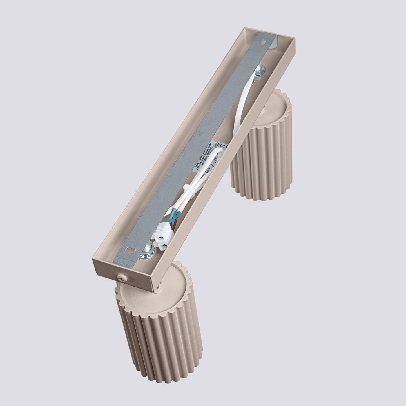 Lampa sufitowa Karbon w kolorze taupe, z dwoma miejscami na żarówki GU10. Posiada prostokątną, gładką podstawę z metalową płytką oraz dwa cylindryczne, żłobkowane uchwyty. Produkt montowany na suficie, widoczny z góry.