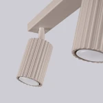Lampa sufitowa Karbon w kolorze taupe z trzema ruchomymi reflektorami GU10. Reflektory mają żłobioną fakturę i okrągłe klosze. Ujęcie z bliska, pokazujące detale lampy oraz jej konstrukcję. Tło jasne, jednolite.