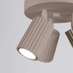 Lampa sufitowa Karbon z trzema reflektorami GU10 w kolorze taupe. Ujęcie z bliska, pokazujące fakturowane klosze o pionowych żłobieniach. Klosze skierowane w dół, montowane na okrągłej podstawie.