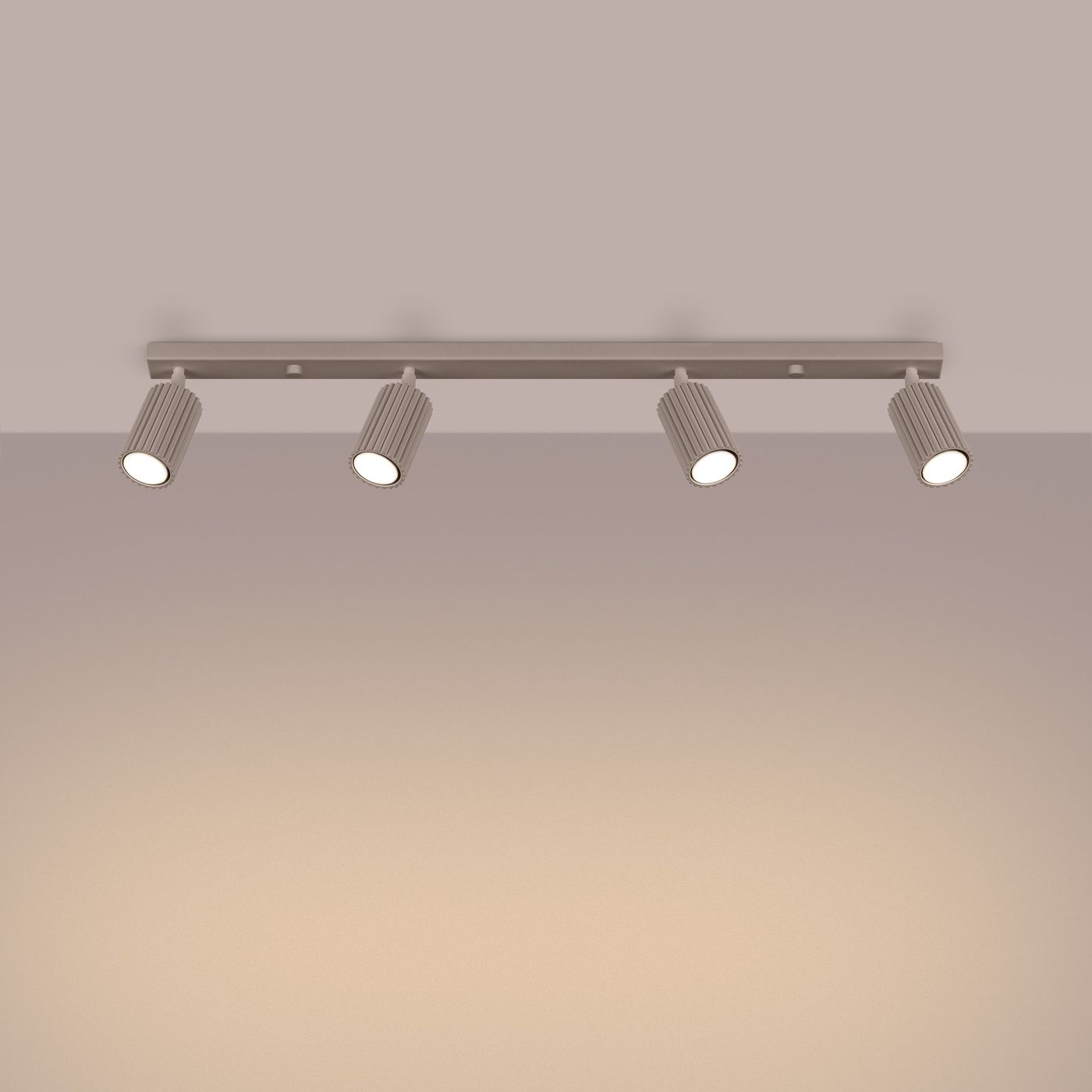 Lampa sufitowa Karbon L w kolorze taupe z czterema regulowanymi reflektorami GU10. Ujęcie frontalne, zamontowana na ścianie, z widocznymi żarówkami i teksturowanymi kloszami. Tło w odcieniu szaro-beżowym.