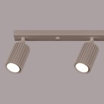 Lampa sufitowa Karbon L w kolorze taupe z czterema reflektorami GU10. Ujęcie z boku, pokazujące cylindryczne, żłobkowane oprawy oraz prostokątny uchwyt montażowy. Tło jednolite, szare.
