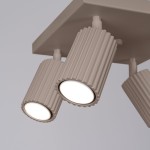 Lampa sufitowa Karbon w odcieniu taupe z czterema punktami świetlnymi GU10. Cylindryczne klosze z rowkowanym wykończeniem, zamontowane na prostokątnej podstawie. Kąt ujęcia zbliżeniowy, ukazujący detale lampy.