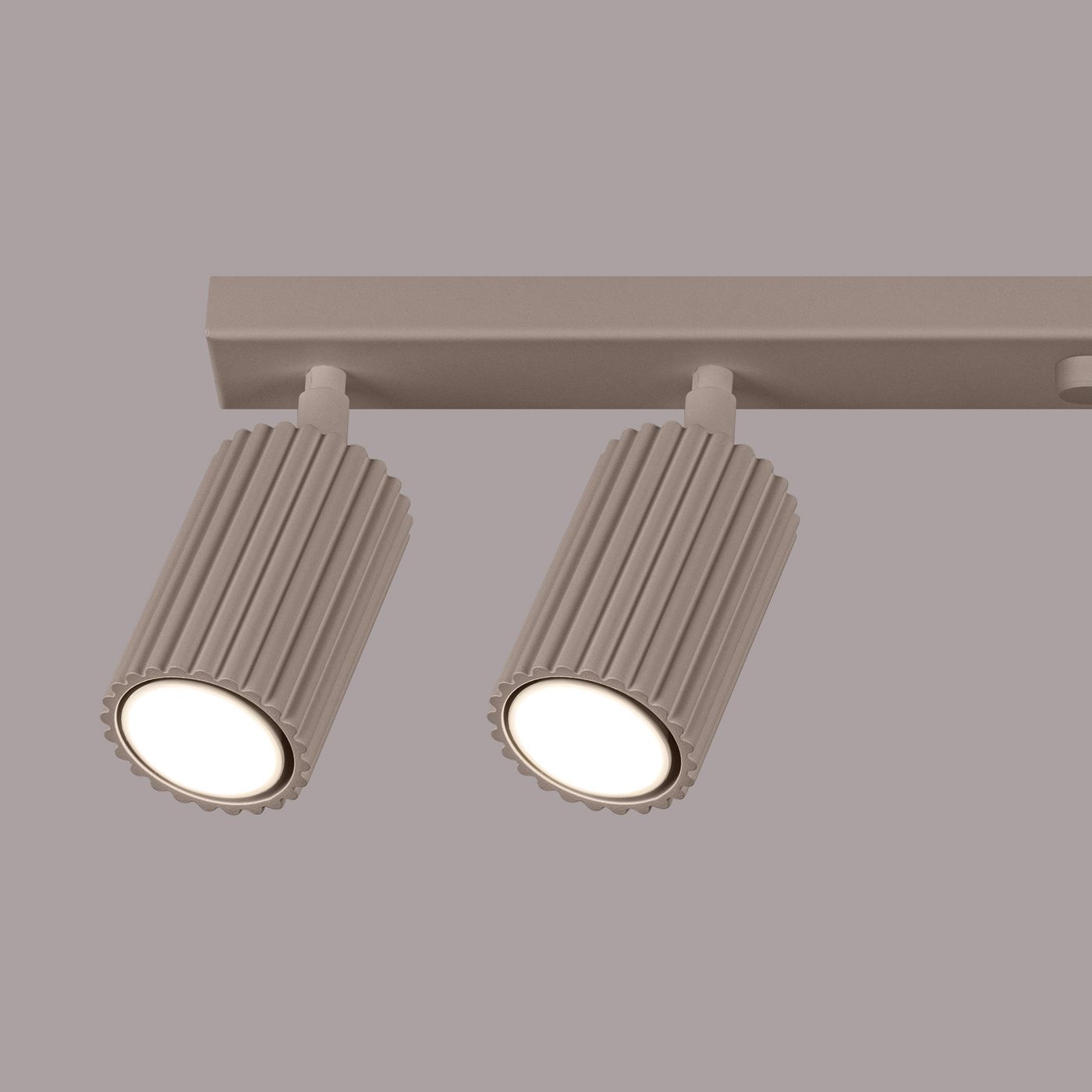 Lampa sufitowa Karbon w kolorze taupe, z sześcioma oprawami GU10. Dwa cylindryczne reflektory z rowkowaną fakturą, zamocowane na prostokątnej podstawie, w stylowym, minimalistycznym designie. Ujęcie z przodu.