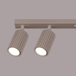 Lampa sufitowa Karbon w kolorze taupe, z sześcioma oprawami GU10. Dwa cylindryczne reflektory z rowkowaną fakturą, zamocowane na prostokątnej podstawie, w stylowym, minimalistycznym designie. Ujęcie z przodu.