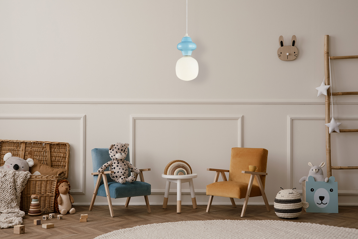Niebieska lampa wisząca Latera D15 z oprawą na jedną żarówkę E14, zawieszona na białym przewodzie, w nowoczesnym, zaokrąglonym kształcie. W tle pokój dziecięcy z kolorowymi fotelami i zabawkami.