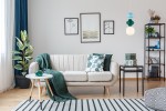 Lampa wisząca Latera 1xE14 w multikolorze, złożona z okrągłej białej części oraz kilku kolorowych elementów w odcieniach zieleni i błękitu. Zawieszona nad sofą w jasnym wnętrzu, dodaje kolorowego akcentu do aranżacji.