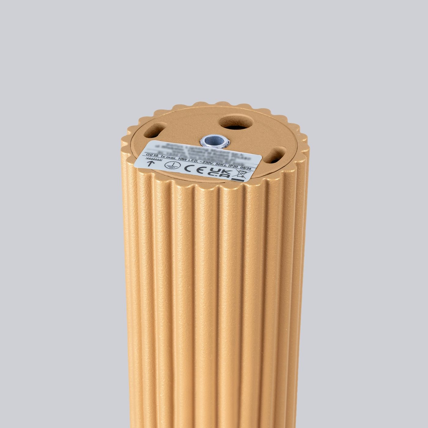 Lampa sufitowa Karbon 40 w kolorze złotym, z teksturowaną, żłobioną powierzchnią. Widoczny gwint na żarówkę GU10 oraz miejsce na montaż. Ujęcie z góry, z bliska, na jednolitym tle.