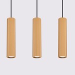 Lampa wisząca Karbon 3 z trzema złotymi, cylindrycznymi kloszami o fakturze żłobkowanej, zawieszona na czarnych przewodach. Klosze są umieszczone równolegle, tworząc nowoczesny design. Tło jasnoszare, co podkreśla kolor lampy.