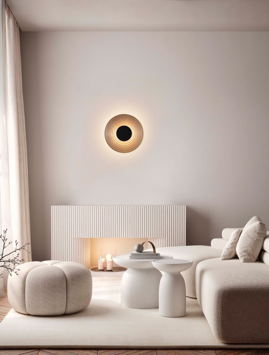 Kinkiet Bermudez 1xLED 8W w kolorze czarnym, zamontowany na ścianie, z okrągłym, falistym abażurem w odcieniach beżu i czerni. W tle nowoczesne wnętrze z jasnymi meblami i dekoracjami.