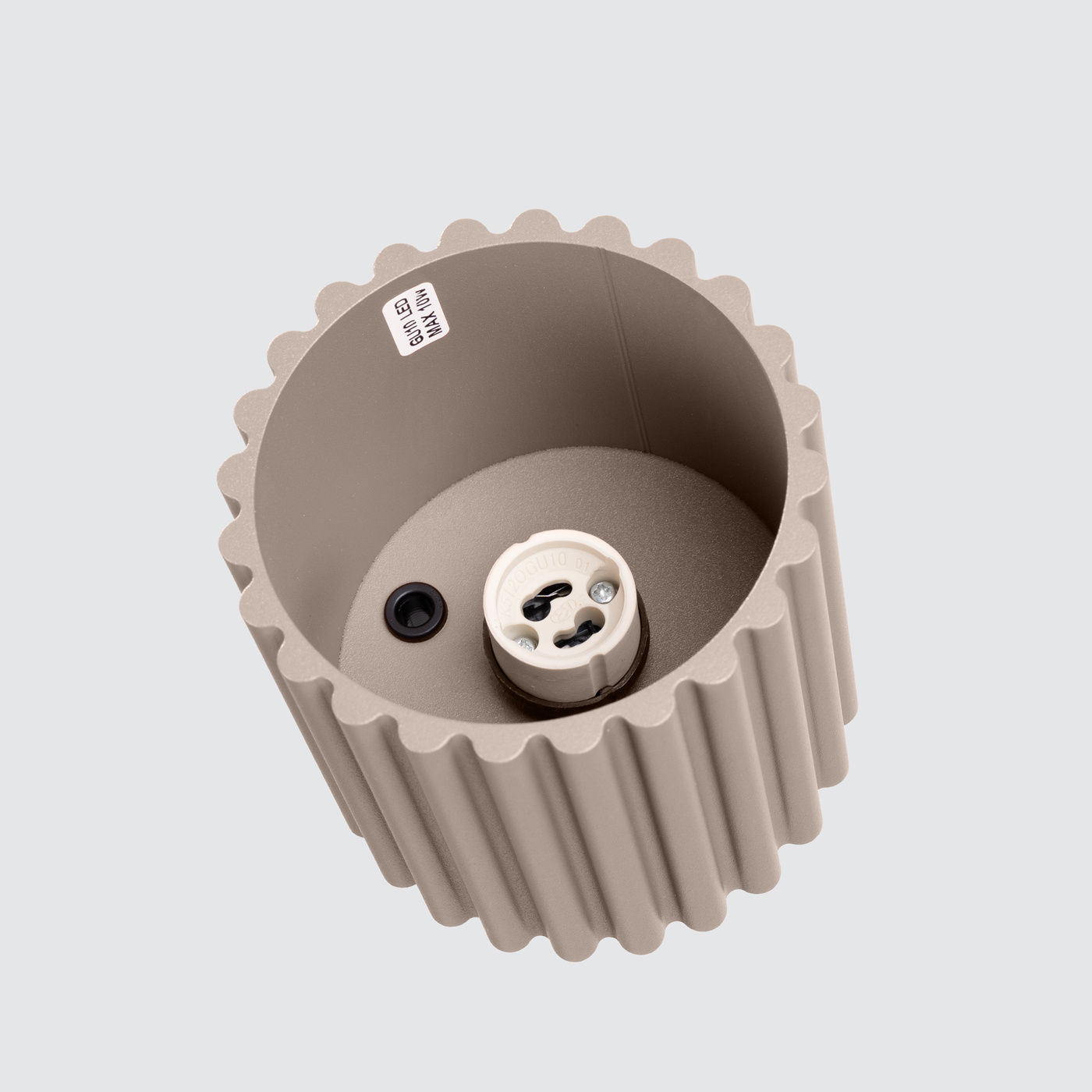 Lampa sufitowa Aura w kolorze taupe, z widocznym gniazdem na żarówkę GU10. Wnętrze lampy ma teksturowaną, falistą strukturę. Ujęcie z góry, pokazujące wnętrze i detale konstrukcyjne.