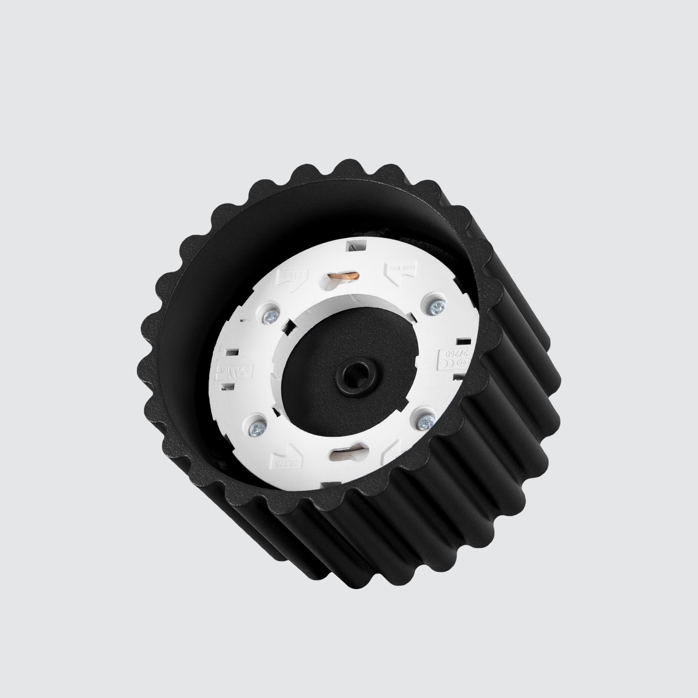 Czarna lampa sufitowa Aura z oprawą GX53, widok z góry. Produkt ma lekko teksturowaną, cylindryczną obudowę z falistymi krawędziami oraz białą podstawkę na żarówkę. Tło jest jasnoszare, co podkreśla detale lampy.