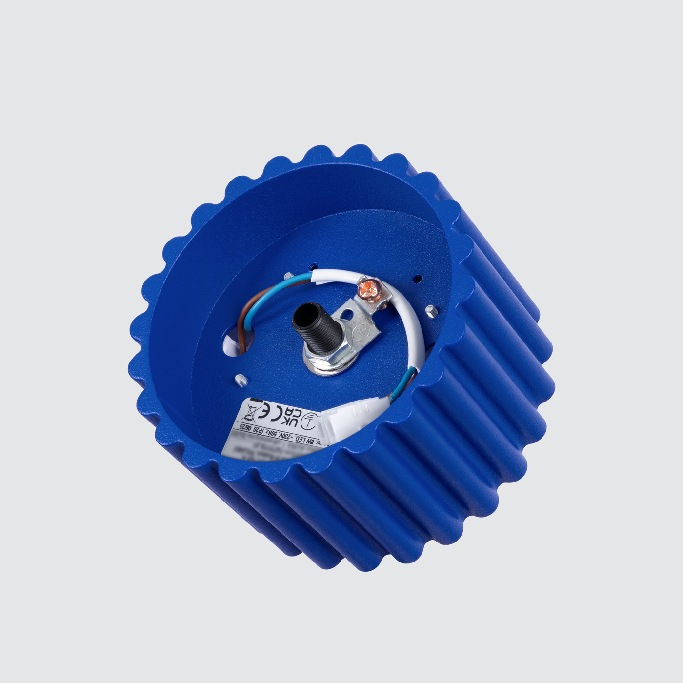 Lampa sufitowa Aura 1xGX53 w kolorze ultramaryny, o okrągłym kształcie z fakturą rowkowaną. Ujęcie z boku, ukazujące wnętrze z przewodami oraz mocowaniem. Tło jasne, neutralne.