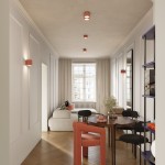 Lampa sufitowa Aura 1xGX53 w kolorze brzoskwiniowym, zamontowana na suficie w nowoczesnym wnętrzu. Widoczne elementy to podłoga z drewnianych paneli oraz meble w neutralnych kolorach. Lampa ma okrągły kształt z delikatnym wykończeniem.