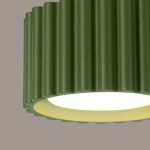 Lampa sufitowa Aura 1xGX53 w kolorze zielonej oliwki, z teksturowanym kloszem w formie falistej, z widocznym źródłem światła na spodzie, zamontowana w górnej części. Tło w odcieniach szaro-beżowych.