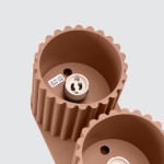 Lampa sufitowa Aura w kolorze mocca z dwoma gniazdami GU10. Widok z góry, ukazujący teksturowane cylindryczne klosze, z widocznymi oznaczeniami maksymalnej mocy 10W dla żarówek LED. Prosty, nowoczesny design.