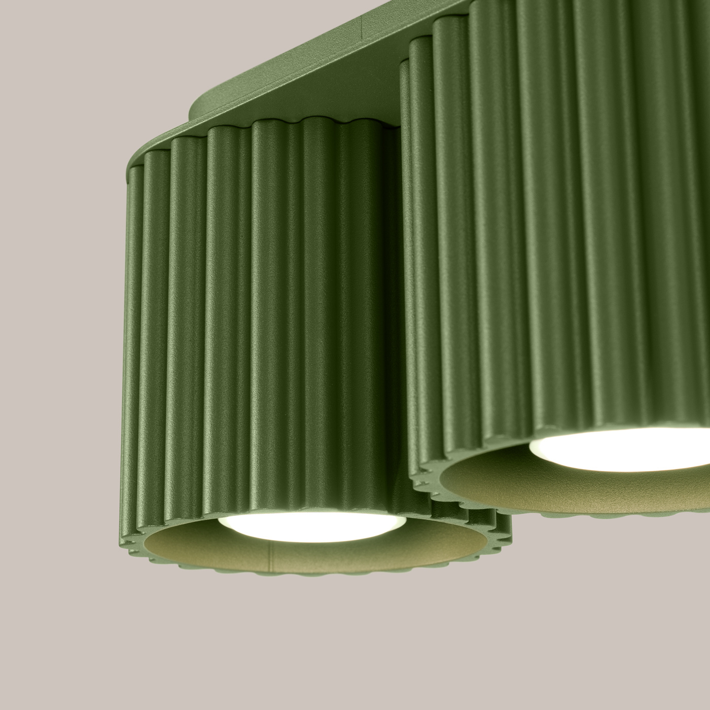 Lampa sufitowa Aura w kolorze oliwkowej zieleni, z dwoma kloszami w formie cylindrów z fakturą żłobioną. Klosze zamontowane na prostokątnej podstawie, w zbliżeniu na detale. Idealna do nowoczesnych wnętrz.