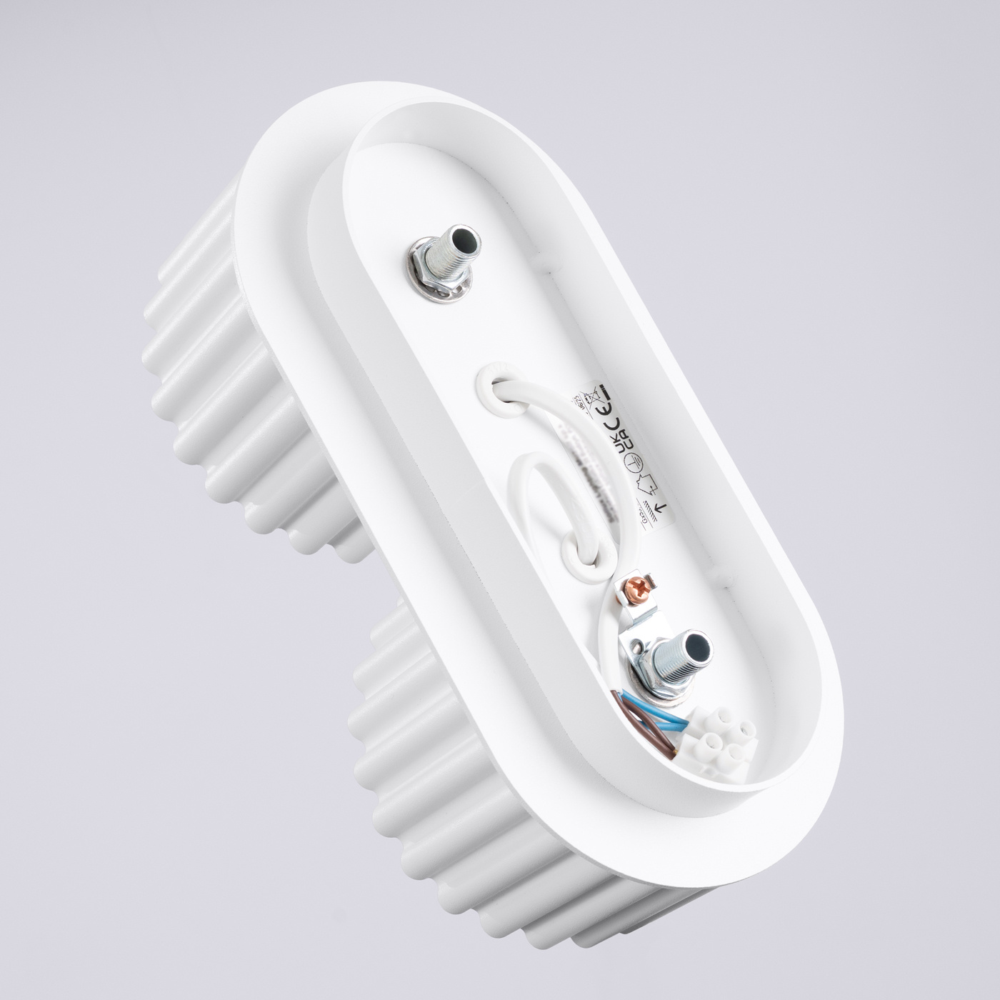 Biała lampa sufitowa Aura z dwoma gniazdami GX53, o owalnym kształcie. Widoczne metalowe elementy mocujące oraz przewody wewnętrzne. Lampa posiada teksturowaną powierzchnię wzdłuż boków, co zwiększa jej estetykę.