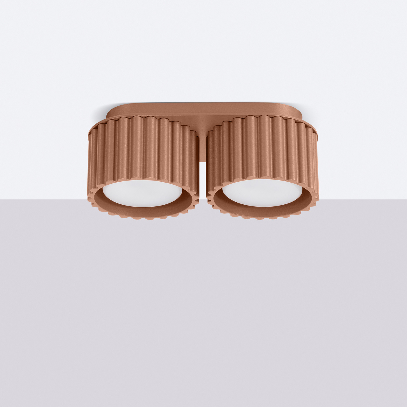 Lampa sufitowa Aura w kolorze mocca, z dwoma cylindrycznymi kloszami z fakturowanej powierzchni. Klosze mają białe wnętrze i osadzone są na prostokątnej podstawie. Produkt zamontowany jest na suficie, na jednolitym tle.
