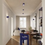 Lampa sufitowa Aura w kolorze ultramaryny z dwoma oprawami na żarówki GX53, zamontowana na suficie w jasnym wnętrzu. Widoczne są również ścienne lampy w tym samym kolorze oraz meble w stylu nowoczesnym.