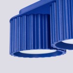 Lampa sufitowa Aura w kolorze ultramaryny z dwoma okrągłymi źródłami światła GX53. Widoczne żłobienia na metalowej obudowie oraz matowe klosze. Kąt ujęcia zbliżenie na detal, z góry, ukazujący strukturę i materiał.
