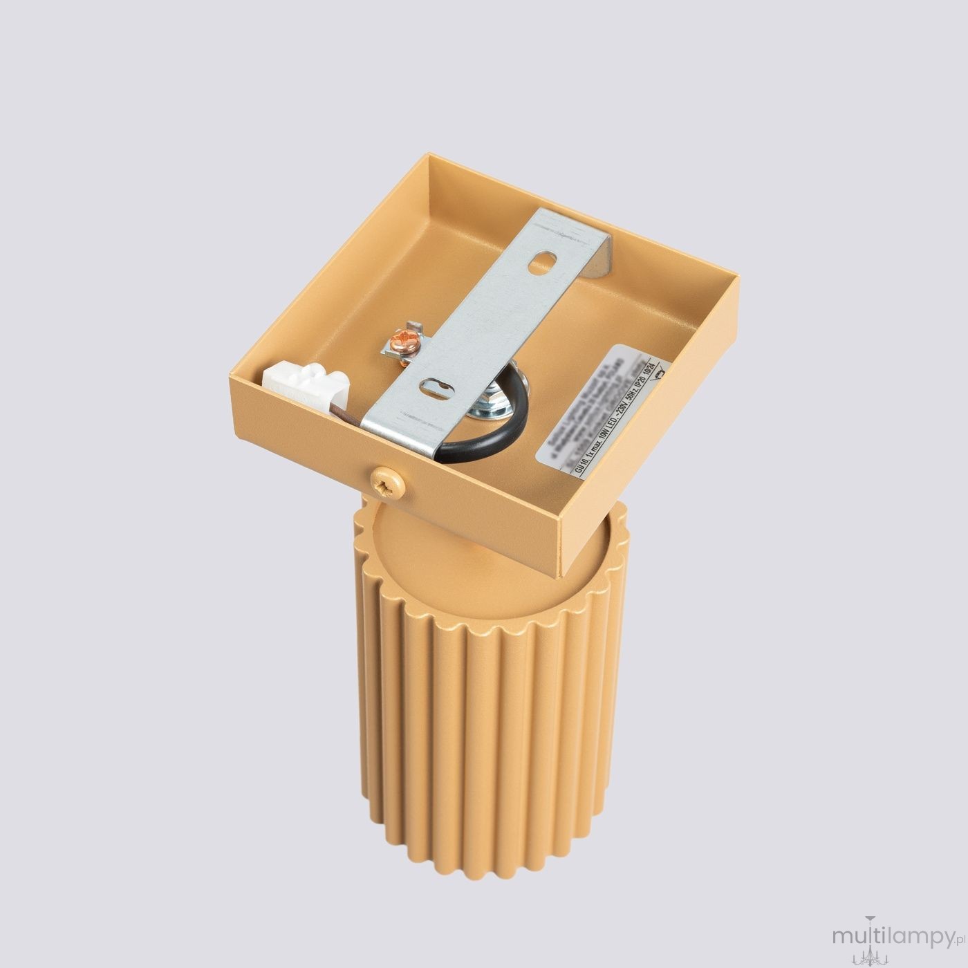 Kinkiet Karbon 1xGU10 w kolorze złotym. Oferuje cylindryczny korpus z teksturą żłobioną. Ujęcie z góry pokazuje metalowy element montażowy oraz gniazdo na żarówkę. Produkt zainstalowany w pozycji pionowej, na jednolitym tle.