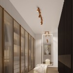 Lampa sufitowa Karbon w kolorze złotym z dwoma reflektorami GU10, zamontowana na suficie w nowoczesnym wnętrzu. Ujęcie z boku, w tle widoczna szafa i duże lustro. Oświetlenie skierowane na przestrzeń, podkreślające styl aranżacji.