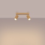 Złota lampa sufitowa Karbon, model SL.1561, z dwoma regulowanymi reflektorami GU10. Ujęcie frontalne, zamontowana na suficie, z widocznymi żłobieniami na korpusach lamp. Tło w odcieniach beżu, co podkreśla elegancki design.
