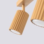 Lampa sufitowa Karbon z trzema reflektorami GU10 w złotym kolorze, z teksturowanym wykończeniem w formie żłobień. Ujęcie z bliska, ukazujące detale klosza i mocowania. Tło jasnoszare, minimalistyczne.