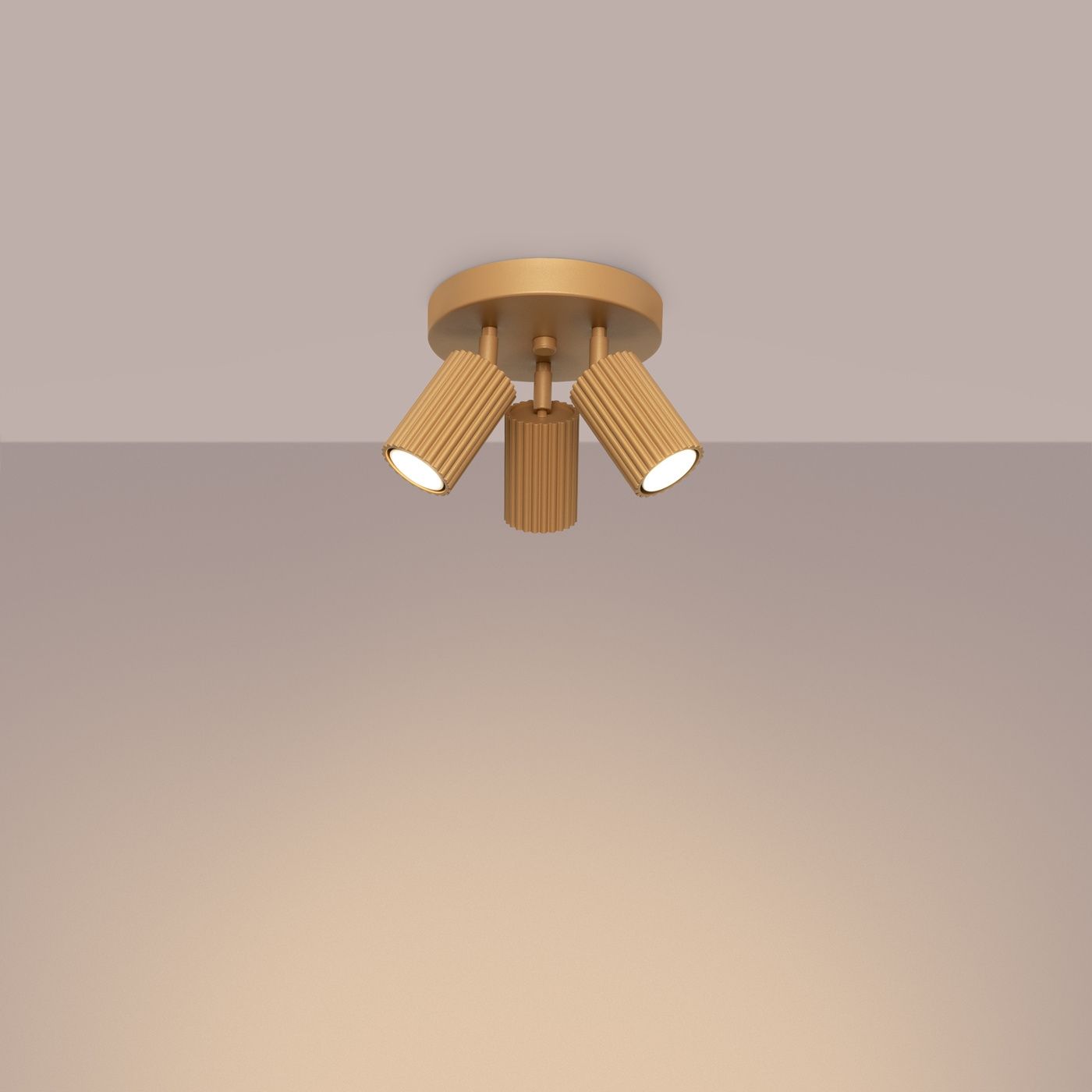 Lampa sufitowa Karbon koło w kolorze złotym, z trzema ruchomymi reflektorami GU10. Reflektory mają teksturowaną, żłobioną powierzchnię. Ujęcie z dołu, montowana na suficie, na jednolitym tle.
