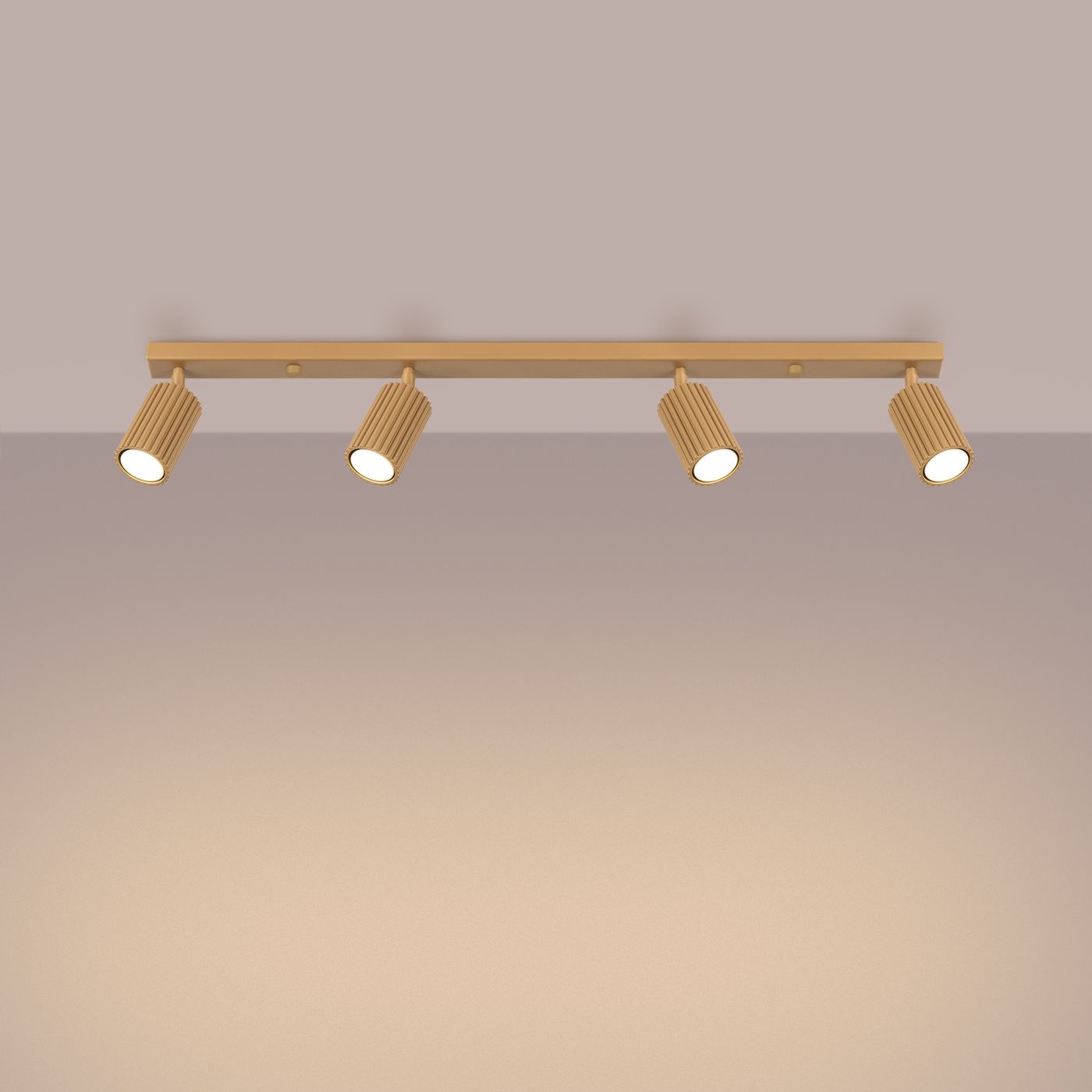 Lampa sufitowa Karbon L w kolorze złotym, z czterema reflektorami GU10. Ujęcie frontalne, zamontowana na ścianie, z elegancką, teksturowaną powierzchnią kloszy. Prosta konstrukcja z metalowym stelażem, idealna do nowoczesnych wnętrz.