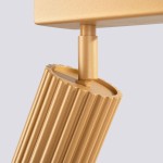 Lampa sufitowa Karbon L w kolorze złotym, z czterema miejscami na żarówki GU10. Ujęcie zbliżeniowe na detal cylindrycznej obudowy z rowkowaniem i mocowaniem. Wysoka jakość wykończenia, matowa powierzchnia, nowoczesny design.