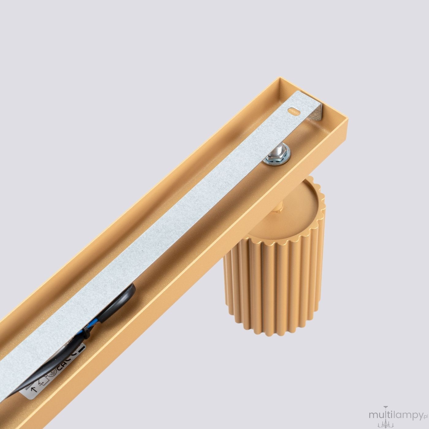 Złota lampa sufitowa Karbon z miejscem na 6 żarówek GU10. Widoczny metalowy element montażowy z teksturowanym uchwytem, w kolorze złotym. Kąt widzenia z góry, ukazujący detal konstrukcji lampy. Tło w jasnym odcieniu.