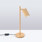 Lampka stołowa Karbon 1xGU10 w kolorze złotym, z cylindryczną, żebrowaną głowicą, zamontowana na prostym, okrągłym stojaku. Widoczny kabel z włącznikiem w kolorze czarnym. Produkt ustawiony na białym tle.