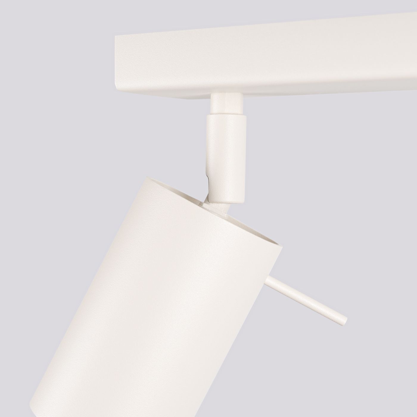 Beżowa lampa sufitowa typu spot z czterema oprawami na żarówki GU10. Ujęcie z boku, pokazujące cylindryczny klosz oraz ruchome mocowanie. Gładka, matowa powierzchnia oraz wykończenie w jasnym odcieniu.