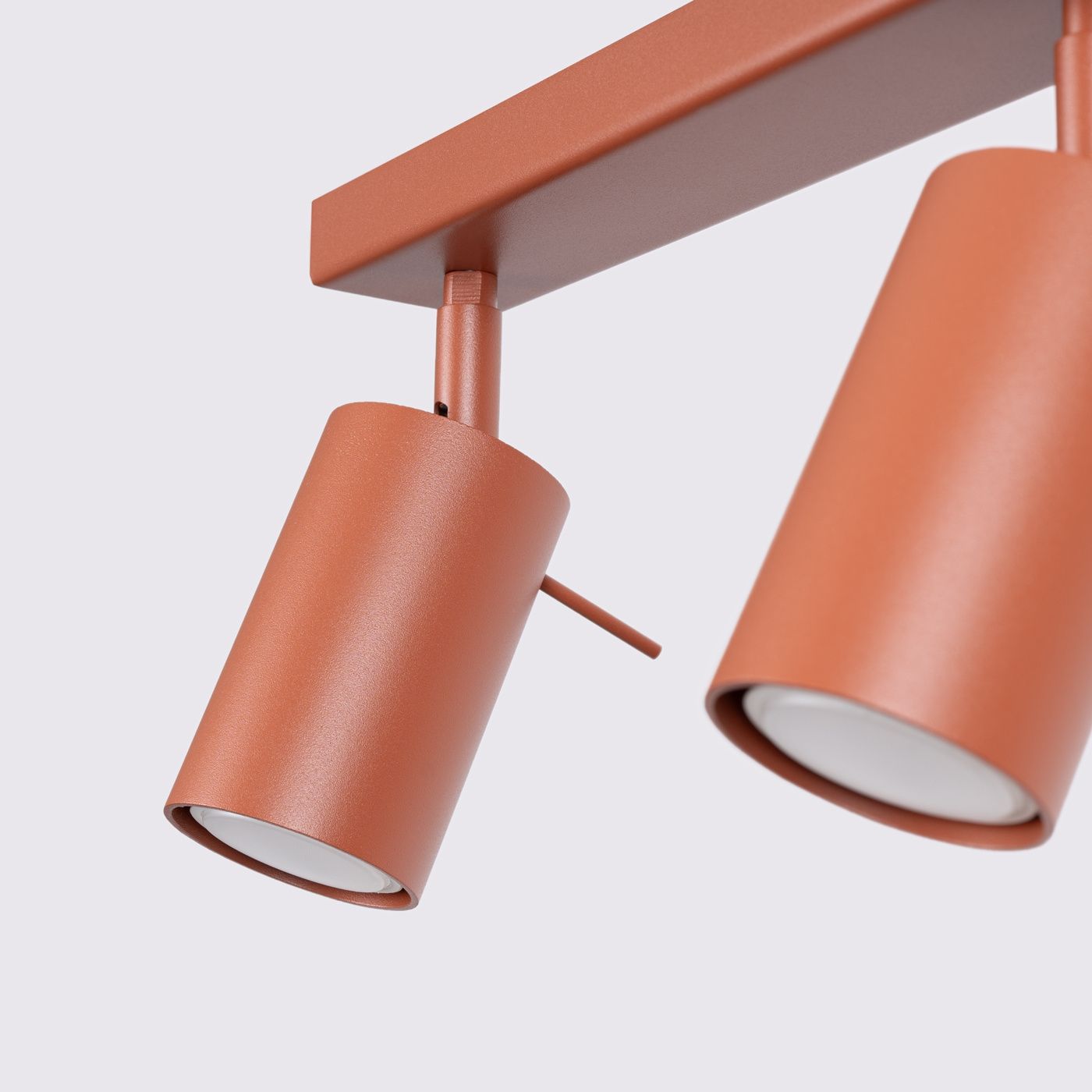 Lampa sufitowa Ring w kolorze ochry czerwonej z trzema reflektorami GU10. Reflektory cylindryczne, zamontowane na prostokątnym stelażu, ustawione pod różnymi kątami. Matowa powierzchnia, nowoczesny design, idealna do oświetlenia wnętrz.