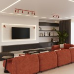 Lampa sufitowa typu spot w kolorze ochra czerwona, z sześcioma miejscami na żarówki GU10, zamontowana na suficie. Ujęcie z boku, w nowoczesnym wnętrzu z telewizorem i półkami.