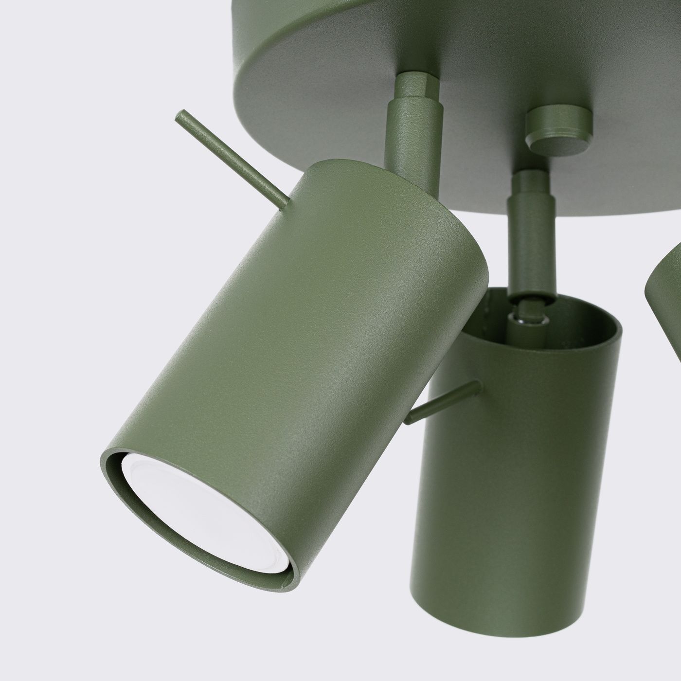 Lampa sufitowa spot w kolorze oliwkowej zieleni z trzema ruchomymi kloszami GU10. Metalowa konstrukcja z matową fakturą, zamontowana na okrągłej podstawie. Klosze mają cylindryczny kształt, skierowane w różnych kierunkach.
