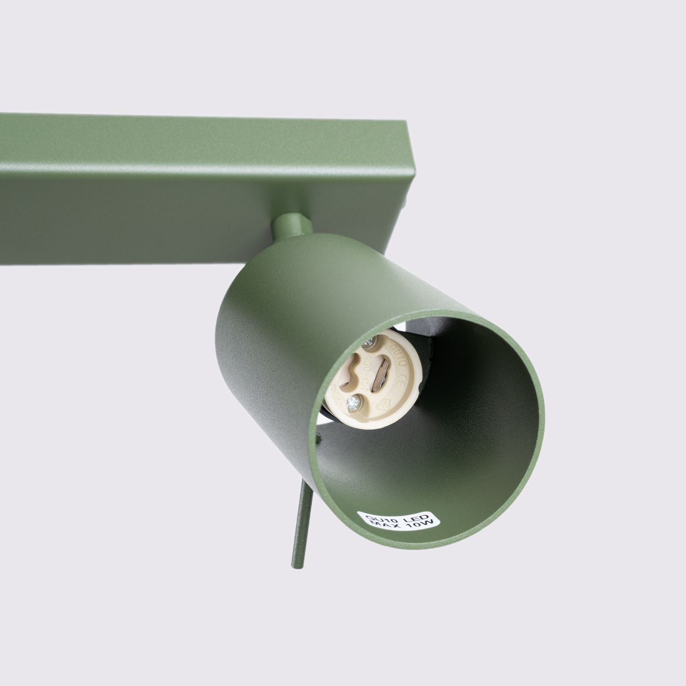 Lampa sufitowa spot w kolorze oliwkowym z czterema oprawami na żarówki GU10. Ujęcie z boku, ukazujące cylindryczny klosz i mocowanie. Metalowa konstrukcja z matowym wykończeniem. Wnętrze klosza jasne, z widocznym gniazdem.